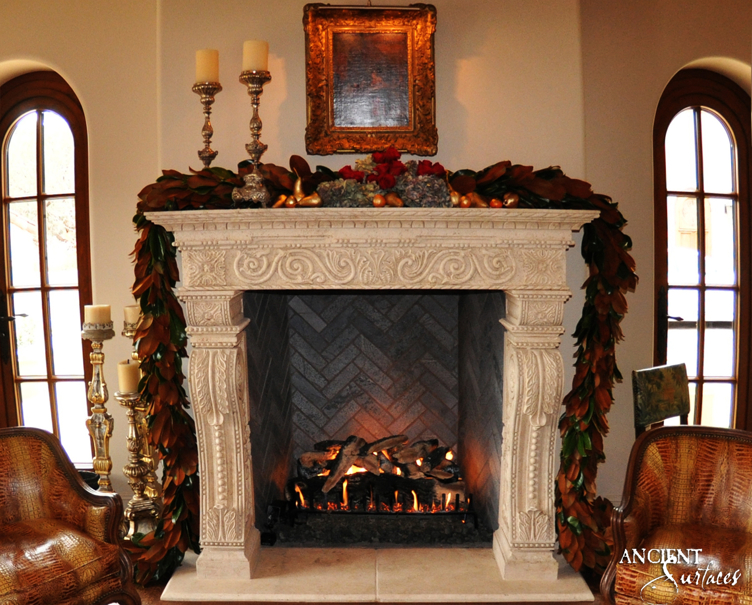 Reclaimed antique limestone fireplace mantel from Ancient Surfaces carved with a running acanthus scroll frieze and acanthus pilaster jambs, installed in a formal living room between two arched windows